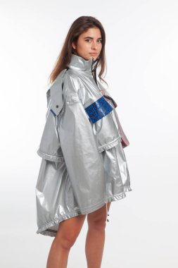 Güzel, seksi, şehvetli kız beyaz arka plan üzerinde fütüristik kentsel giysiler ile poz