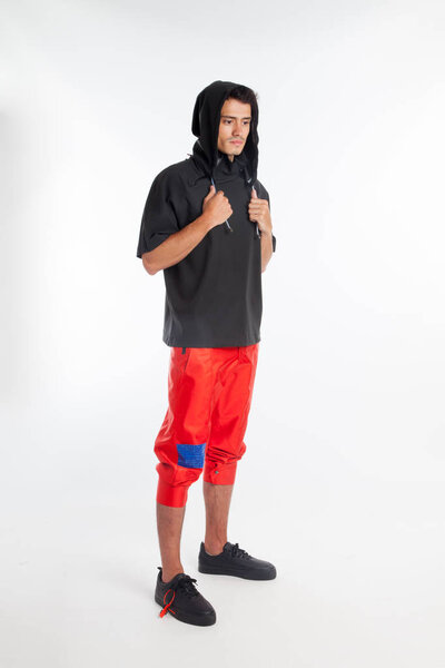 Красивый, сексуальный молодой парень с футуристической современной одеждой, городской дизайнерской одеждой на белом фоне
