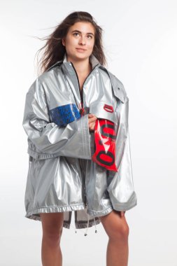 Güzel, seksi, şehvetli kız beyaz arka plan üzerinde fütüristik kentsel giysiler ile poz