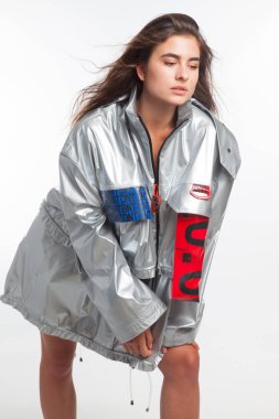 Güzel, seksi, şehvetli kız beyaz arka plan üzerinde fütüristik kentsel giysiler ile poz