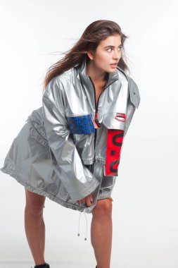 Güzel, seksi, şehvetli kız beyaz arka plan üzerinde fütüristik kentsel giysiler ile poz