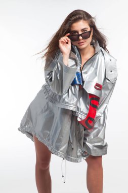 Güzel, seksi, şehvetli kız beyaz arka plan üzerinde fütüristik kentsel giysiler ile poz