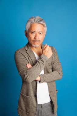 Japon kökenli orta yaşlı bir adam, elleri ve kollarıyla el kol hareketi yapıyor, etkileyici bir adam..