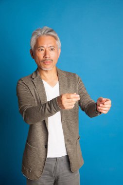 Japon kökenli orta yaşlı bir adam, elleri ve kollarıyla el kol hareketi yapıyor, etkileyici bir adam..