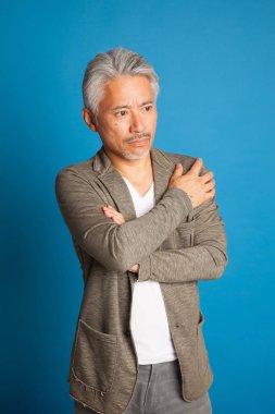 Japon kökenli orta yaşlı bir adam, elleri ve kollarıyla el kol hareketi yapıyor, etkileyici bir adam..