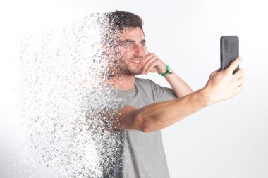 Genç adam akıllı telefonuyla fotoğraf çekiyor ve vücudunu parçalıyor. Elektromanyetik kirlilik, transmisin de datos.