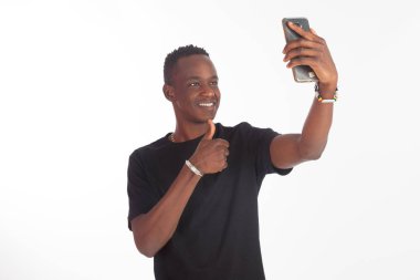 Afrika kökenli genç telefonunuzla selfie çekiyor.