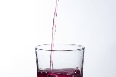 Temiz, içme suyu temiz bir bardağa dökülüyor, sağlıklı, sağlıklı, temiz, kokusuz ve tatsız bir su. Yüzeye su damlaları sıçrıyor. Jet su bardağa giriyor