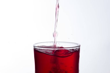 Temiz, içme suyu temiz bir bardağa dökülüyor, sağlıklı, sağlıklı, temiz, kokusuz ve tatsız bir su. Yüzeye su damlaları sıçrıyor. Jet su bardağa giriyor