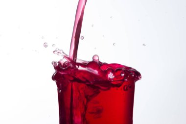 Temiz, içme suyu temiz bir bardağa dökülüyor, sağlıklı, sağlıklı, temiz, kokusuz ve tatsız bir su. Yüzeye su damlaları sıçrıyor. Jet su bardağa giriyor