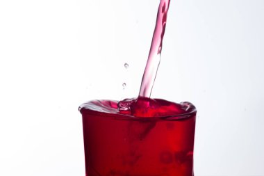 Temiz, içme suyu temiz bir bardağa dökülüyor, sağlıklı, sağlıklı, temiz, kokusuz ve tatsız bir su. Yüzeye su damlaları sıçrıyor. Jet su bardağa giriyor