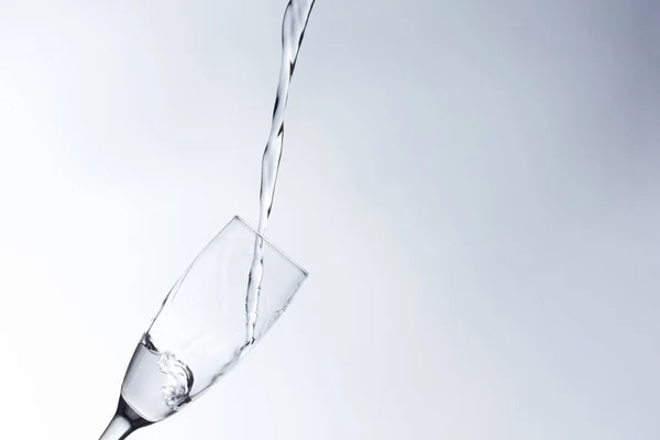 澄んだ飲料水は 澄んだガラス 健康的で健全な 臭いや味のない新鮮な水に落ちます 水のスプラッシュは 表面に飛び散った ガラスに入った水のジェット — ストック写真
