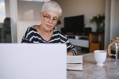 Olgun güzel kadın onu laptop çalışırken notları verme 