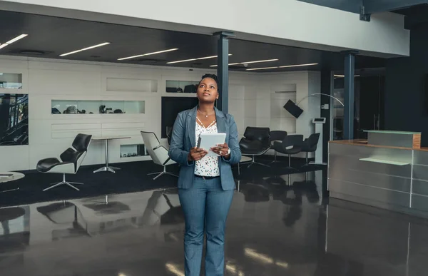 Schöne schwarzafrikanische Geschäftsfrau steht in moderner Lobby — Stockfoto