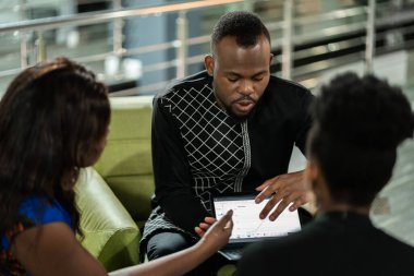 Siyahi Afrikalı işadamı yeni bir şirket kurmak için dijital tablet kullanarak istatistik sunuyor