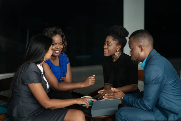 現代のオフィスでのカジュアルなミーティング中に一緒に話している若いアフリカのビジネスマンの笑顔グループ — ストック写真