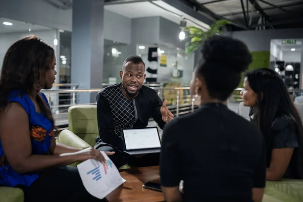 在一个现代办公室的会议上 年轻的非洲商人在平板电脑上与同事讨论数字 — 图库照片