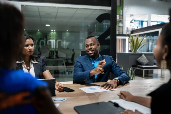 Jovem Empresário Africano Sorridente Conversando Com Colegas Durante Uma Reunião — Fotografia de Stock