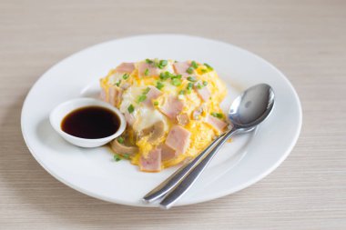 Omlet domuz eti ile pastırma pirinç kesip sos beyaz seramik tabak ve kaşık ve çatal
