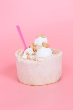 Hindistan cevizi dondurma taze Hindistan cevizi meyve pembe bir arka plan üzerinde pembe kaşık ile