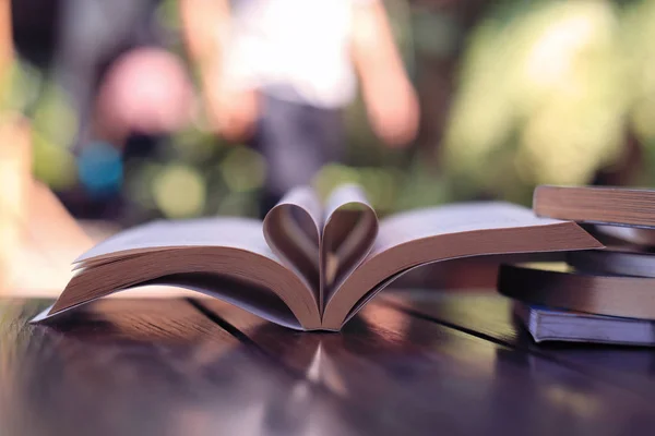 Thick book, heart paper's page folding with green bokeh as background