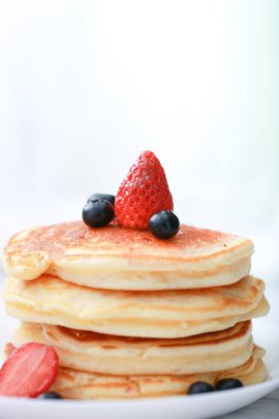 Çilekli krep ve akçaağaç şuruplu yaban mersini. Tatlı bal krep üzerine dökülür 