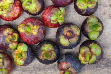 Ahşap masada taze kırmızı ve mor mangosen. Meyve kraliçesi, Anti-Anging için iyi. Sert kabuğu soyduktan sonra beyaz meyveli Asya yerel Tayland meyveleri.