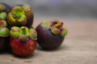 Ahşap masada taze kırmızı ve mor mangosen. Meyve kraliçesi, Anti-Anging için iyi. Sert kabuğu soyduktan sonra beyaz meyveli Asya yerel Tayland meyveleri.