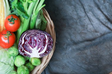 Taze sebzeler yemek yapmak için hazırlanıyor. Marul, yeşil maydanoz, tatlı mısır, domates, lahana, arkaplan olarak rustik bez kaplı çan biberi var.