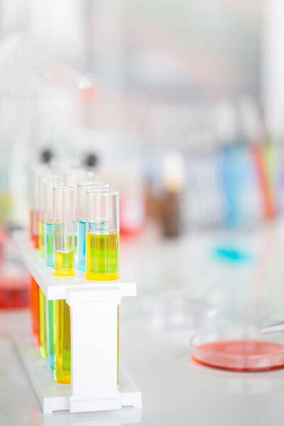 Chemical tubes set development and pharmacy in laboratory with green bokeh through windows