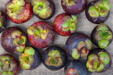 Ahşap masada taze kırmızı ve mor mangosen. Meyve kraliçesi, Anti-Anging için iyi. Sert kabuğu soyduktan sonra beyaz meyveli Asya yerel Tayland meyveleri.
