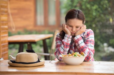 Asyalı kadın sağlıklı salatasının tadını çıkarıyor. Bahçedeki büyük beyaz kasede kıtır kıtır salata yiyor.