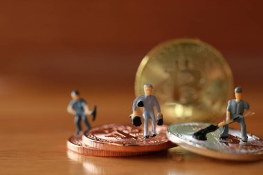 Mühendislik işçisi para kazıyor ve iş ve endüstri konsepti olarak para ile çalışıyor. Altın, gümüş, bronz madeni para ile para kazanmak için çok çalışmak gibi.