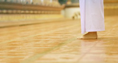 Beyaz giysili Budizm, sakin bir yürüyüşle meditasyon yapıyor. Beyaz giysili kadın Budizm 'de meditasyon için tapınağa giriyor. Jong Krom.