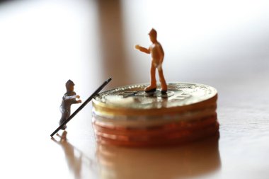 Mühendislik işçisi para kazıyor ve iş ve endüstri konsepti olarak para ile çalışıyor. Altın, gümüş, bronz madeni para ile para kazanmak için çok çalışmak gibi.