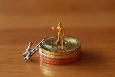 Mühendislik işçisi para kazıyor ve iş ve endüstri konsepti olarak para ile çalışıyor. Altın, gümüş, bronz madeni para ile para kazanmak için çok çalışmak gibi.