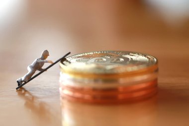 Mühendislik işçisi para kazıyor ve iş ve endüstri konsepti olarak para ile çalışıyor. Altın, gümüş, bronz madeni para ile para kazanmak için çok çalışmak gibi.