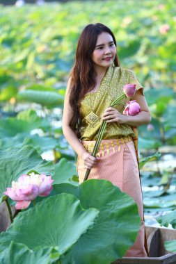 Taylandlı kadın geleneksel Ayutthaya elbisesi Lotus havuzunda eski bir tekneyle.