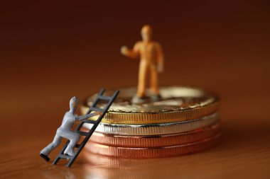 Mühendislik işçisi para kazıyor ve iş ve endüstri konsepti olarak para ile çalışıyor. Altın, gümüş, bronz madeni para ile para kazanmak için çok çalışmak gibi.