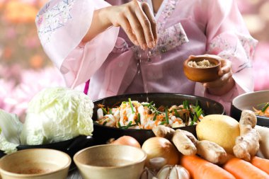 Kimchi hazırlıkları sırasında kadın ellerinin yakınlaştırılması. Kore mutfağının ünlü mezeleri, mayalanmış sebzeler, lahana, turp, baharatlı ve kokulu baharatlar elma, armut, soğan, sarımsak, zencefil ve taze soğan dahil.