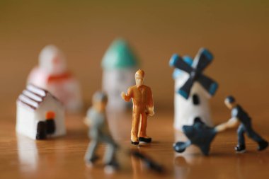 Küçük bir ev, küçük bir yel değirmeni, minyatür bir şehir kadar küçük bir kule ahşap zemindeki kötü oyuncaklar gibi işçilerle birlikte çalışma ve yaşama kavramında.