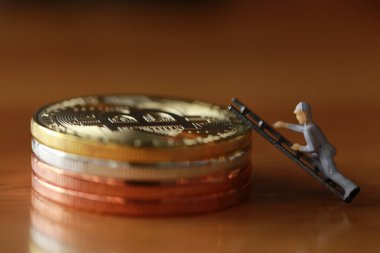 Mühendislik işçisi para kazıyor ve iş ve endüstri konsepti olarak para ile çalışıyor. Altın, gümüş, bronz madeni para ile para kazanmak için çok çalışmak gibi.