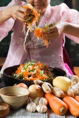 Kimchi hazırlıkları sırasında kadın ellerinin yakınlaştırılması. Kore mutfağının ünlü mezeleri, mayalanmış sebzeler, lahana, turp, baharatlı ve kokulu baharatlar elma, armut, soğan, sarımsak, zencefil ve taze soğan dahil.