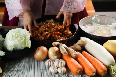 Kimchi hazırlıkları sırasında kadın ellerinin yakınlaştırılması. Kore mutfağının ünlü mezeleri, mayalanmış sebzeler, lahana, turp, baharatlı ve kokulu baharatlar elma, armut, soğan, sarımsak, zencefil ve taze soğan dahil.