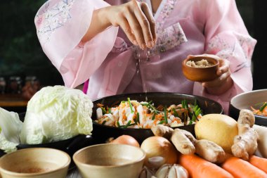 Kimchi hazırlıkları sırasında kadın ellerinin yakınlaştırılması. Kore mutfağının ünlü mezeleri, mayalanmış sebzeler, lahana, turp, baharatlı ve kokulu baharatlar elma, armut, soğan, sarımsak, zencefil ve taze soğan dahil.