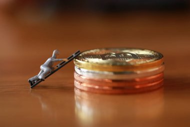 Mühendislik işçisi para kazıyor ve iş ve endüstri konsepti olarak para ile çalışıyor. Altın, gümüş, bronz madeni para ile para kazanmak için çok çalışmak gibi.