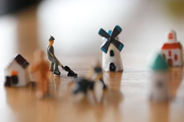 Küçük bir ev, küçük bir yel değirmeni, minyatür bir şehir kadar küçük bir kule ahşap zemindeki kötü oyuncaklar gibi işçilerle birlikte çalışma ve yaşama kavramında.