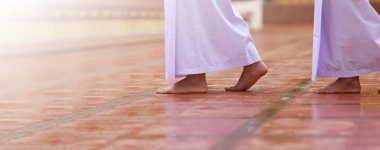 Beyaz giysili Budizm, sakin bir yürüyüşle meditasyon yapıyor. Beyaz giysili kadın Budizm 'de meditasyon için tapınağa giriyor. Jong Krom.