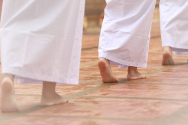 Beyaz giysili Budizm, sakin bir yürüyüşle meditasyon yapıyor. Beyaz giysili kadın Budizm 'de meditasyon için tapınağa giriyor. Jong Krom.