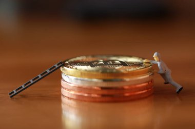 Mühendislik işçisi para kazıyor ve iş ve endüstri konsepti olarak para ile çalışıyor. Altın, gümüş, bronz madeni para ile para kazanmak için çok çalışmak gibi.